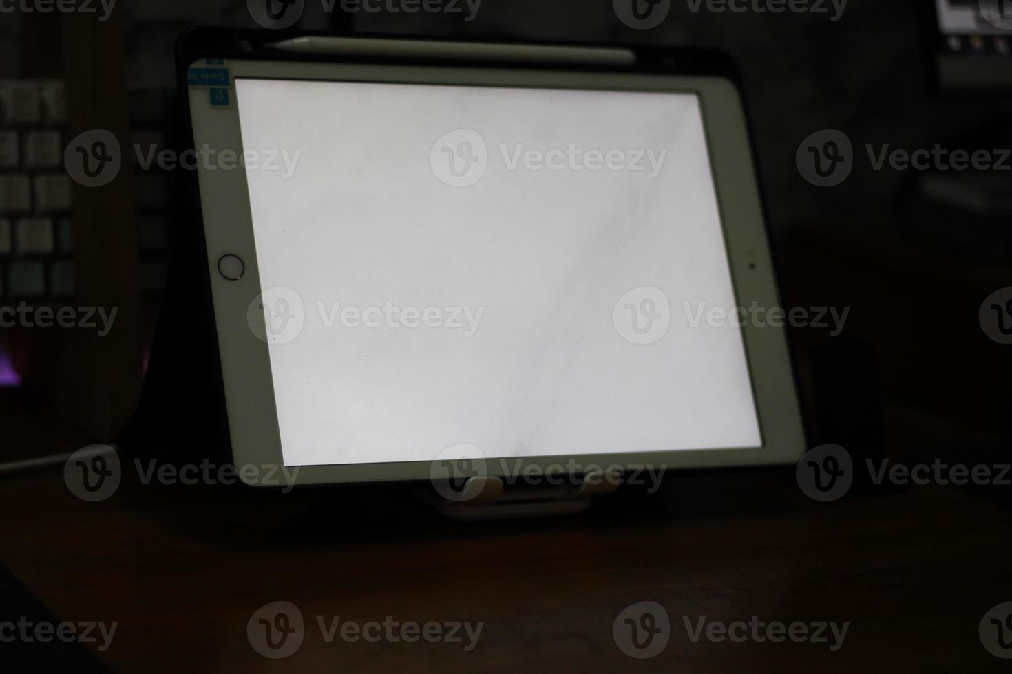 Photo of an empty tablet with white screen on the table