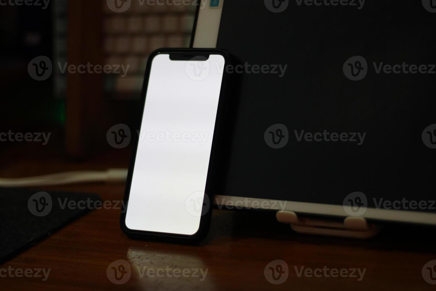 Photo of an empty cell phone with white screen on the table