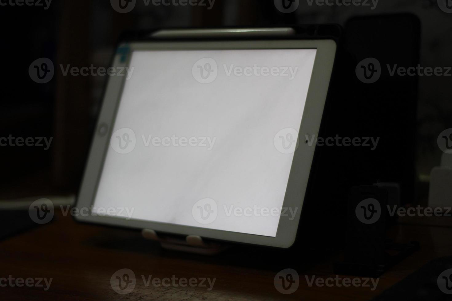 Photo of an empty tablet with white screen on the table