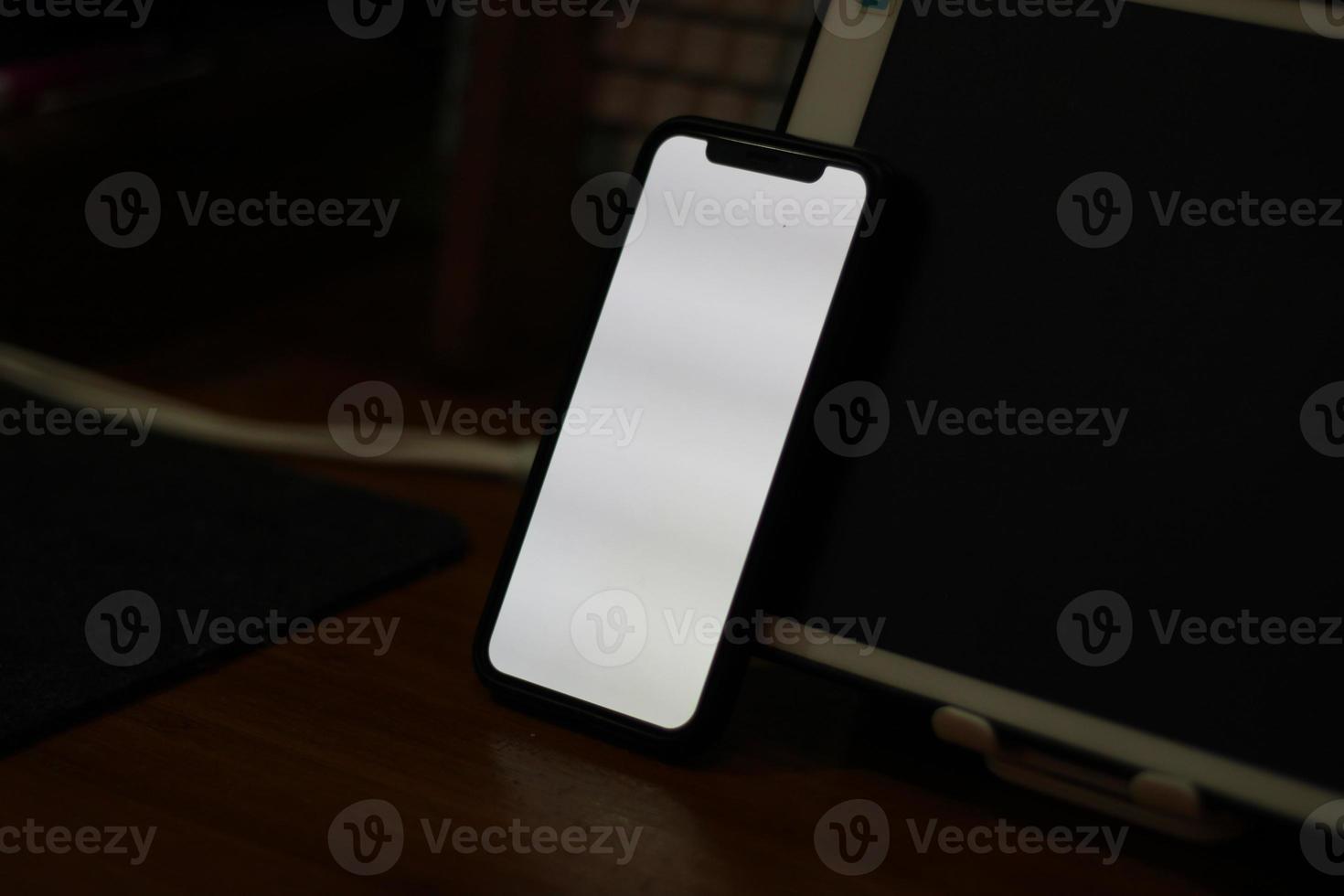 Photo of an empty cell phone with white screen on the table