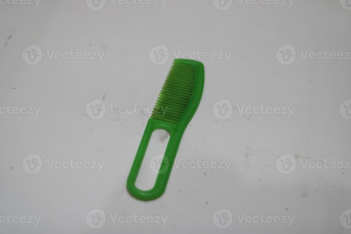 photo of a green hair comb made of plastic with a white background