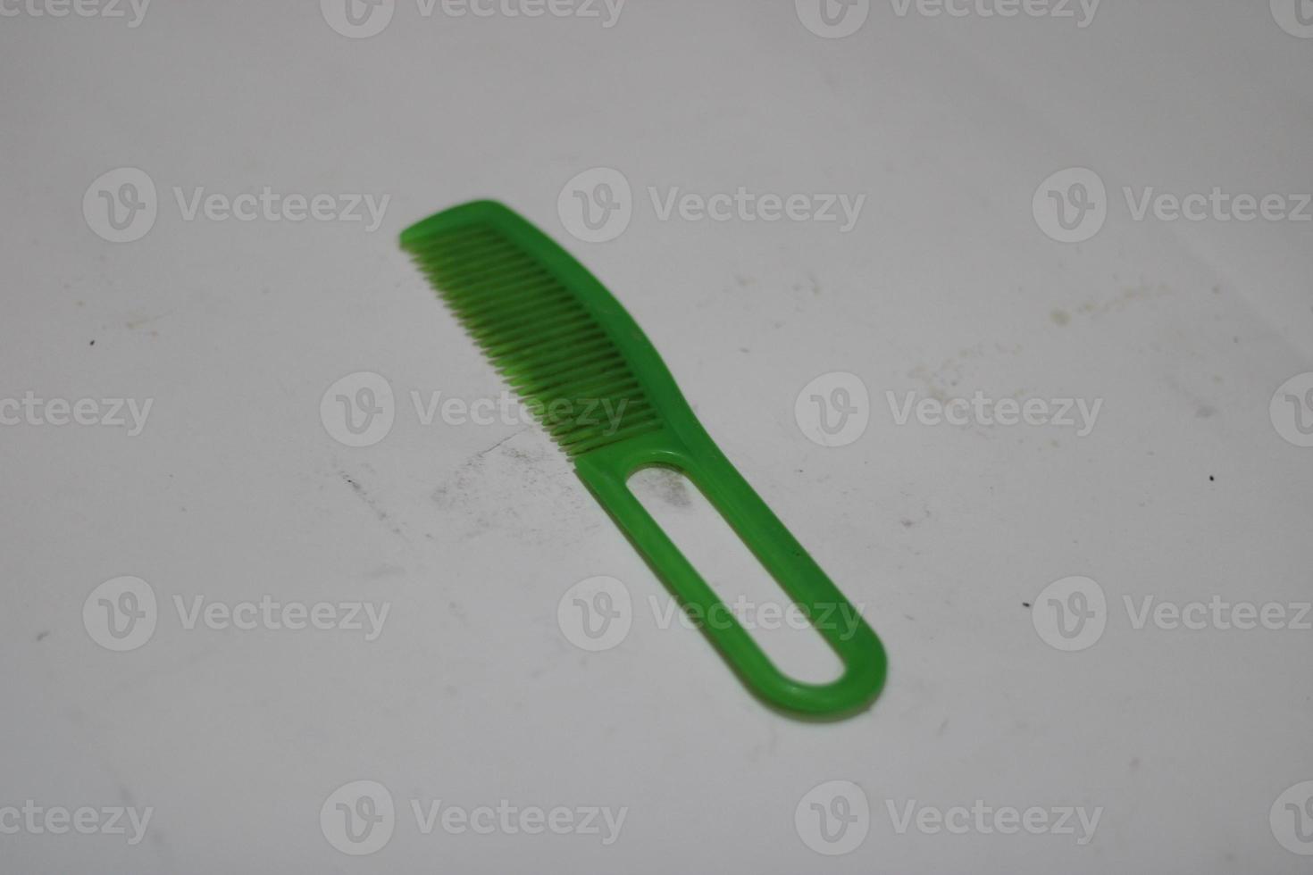 photo of a green hair comb made of plastic with a white background