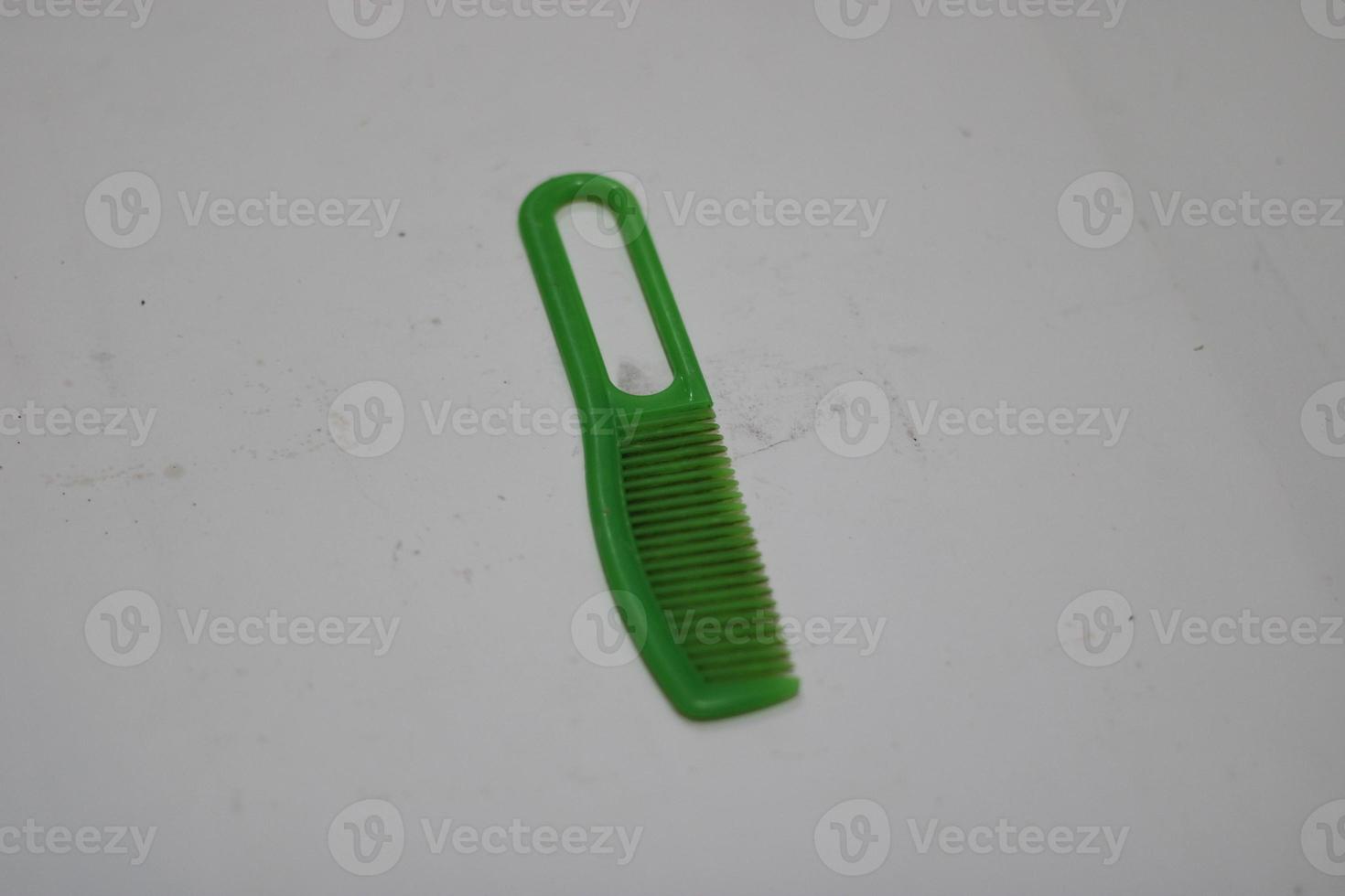 photo of a green hair comb made of plastic with a white background