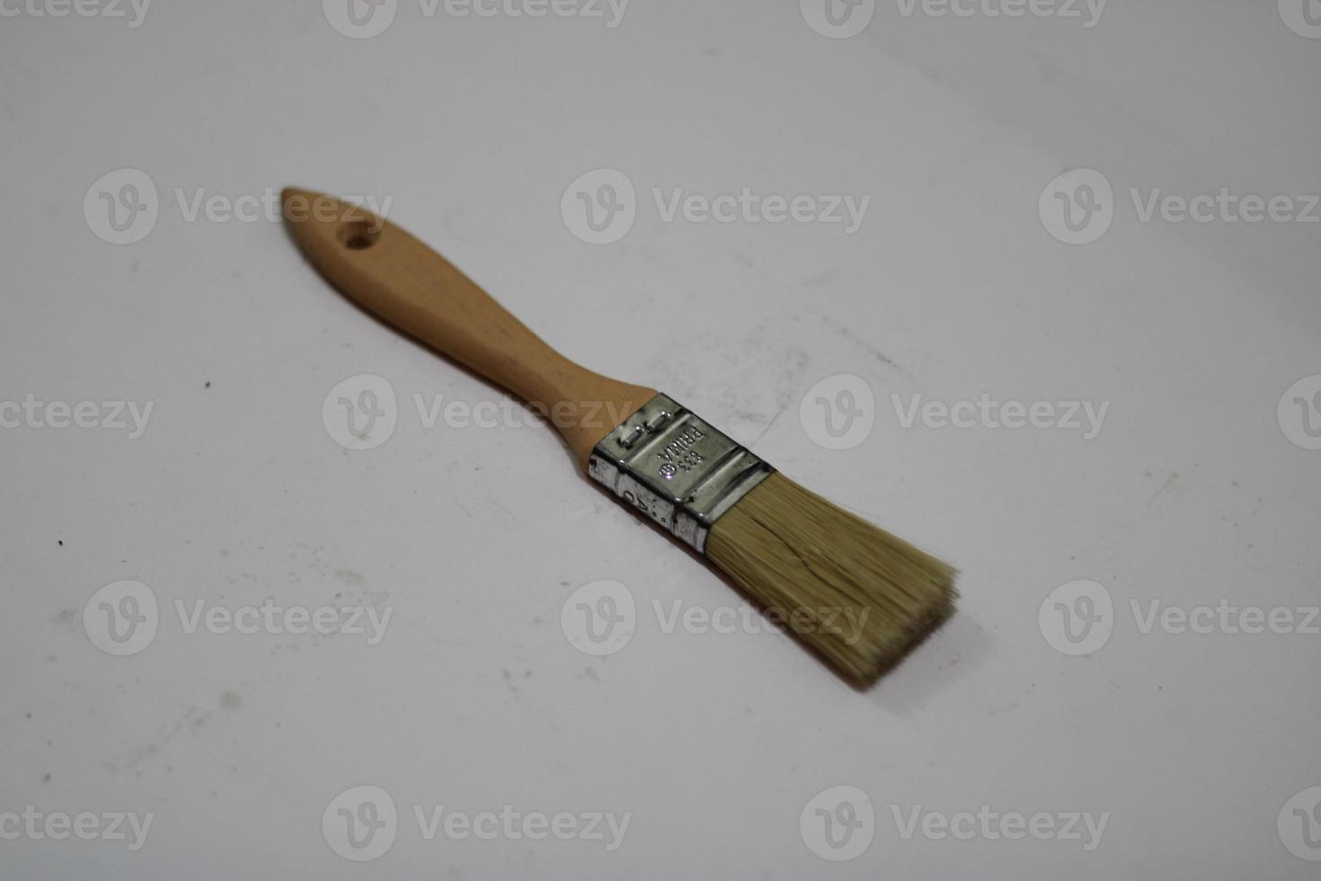 photo of a yellow brush made of wood with a white background