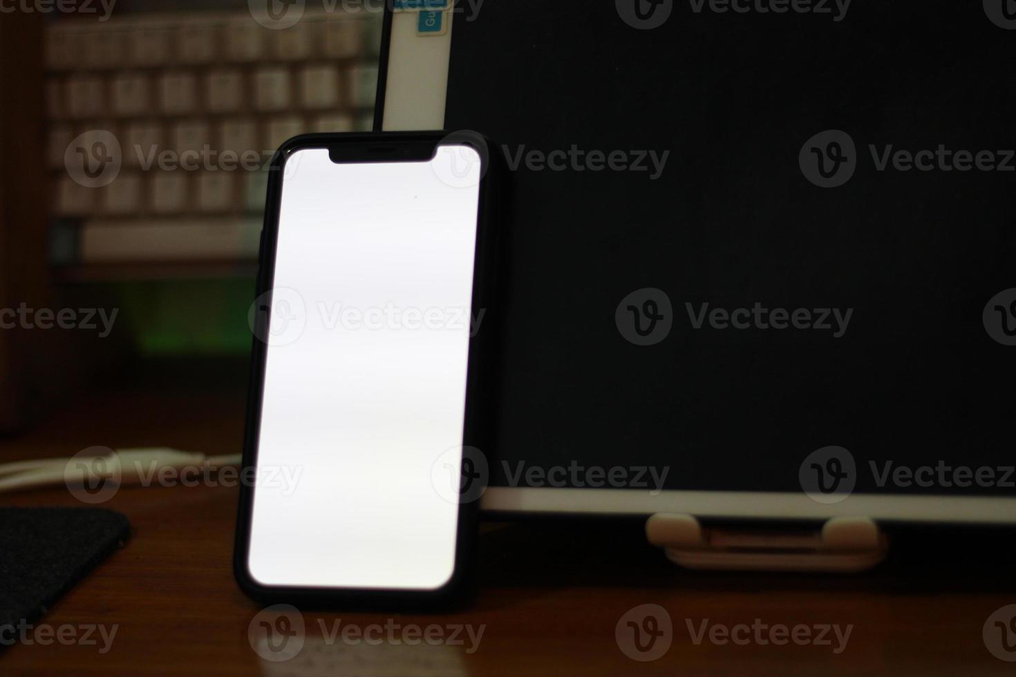 Photo of an empty cell phone with white screen on the table