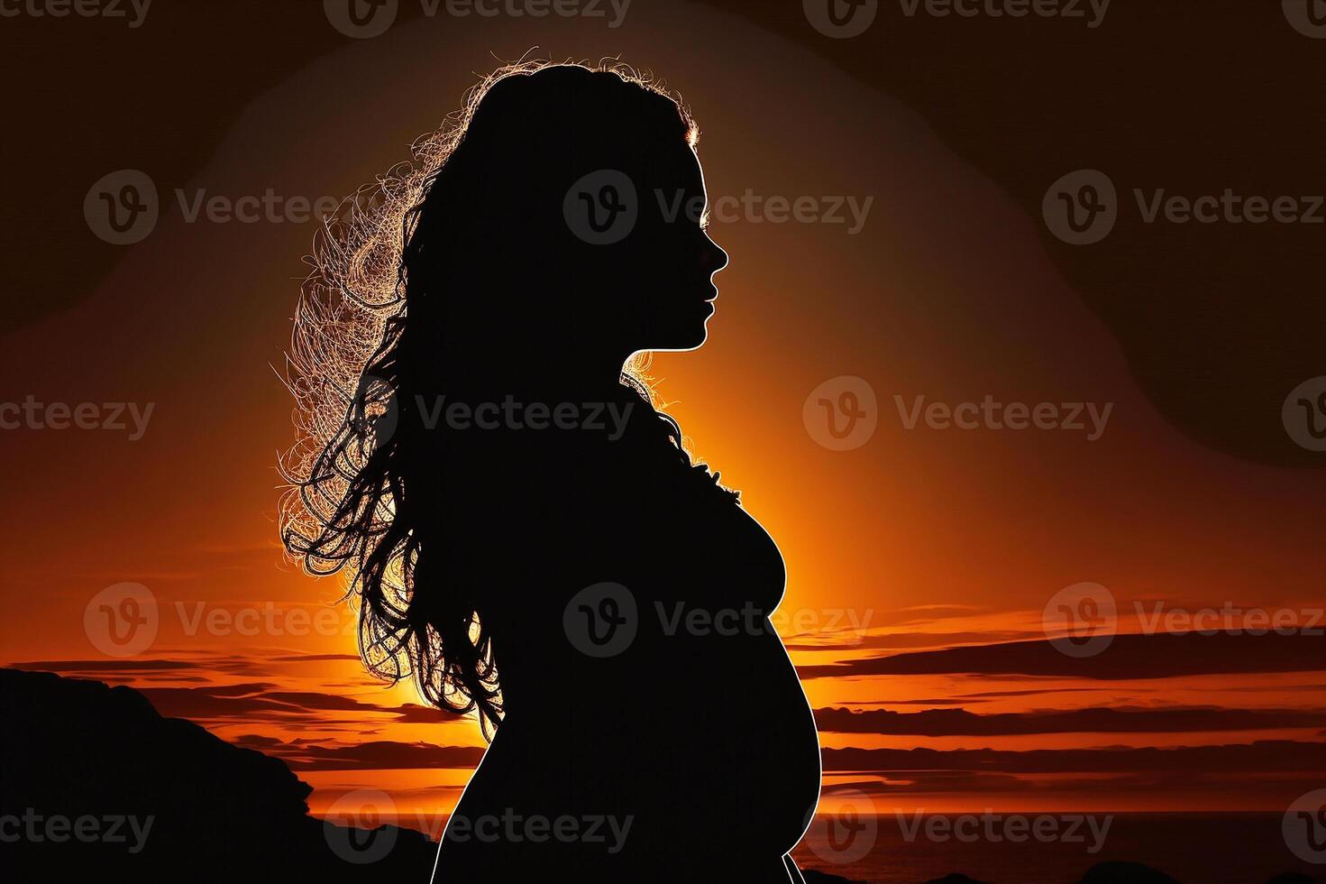 Silhouette of a pregnant woman against the background of the sunset. photo