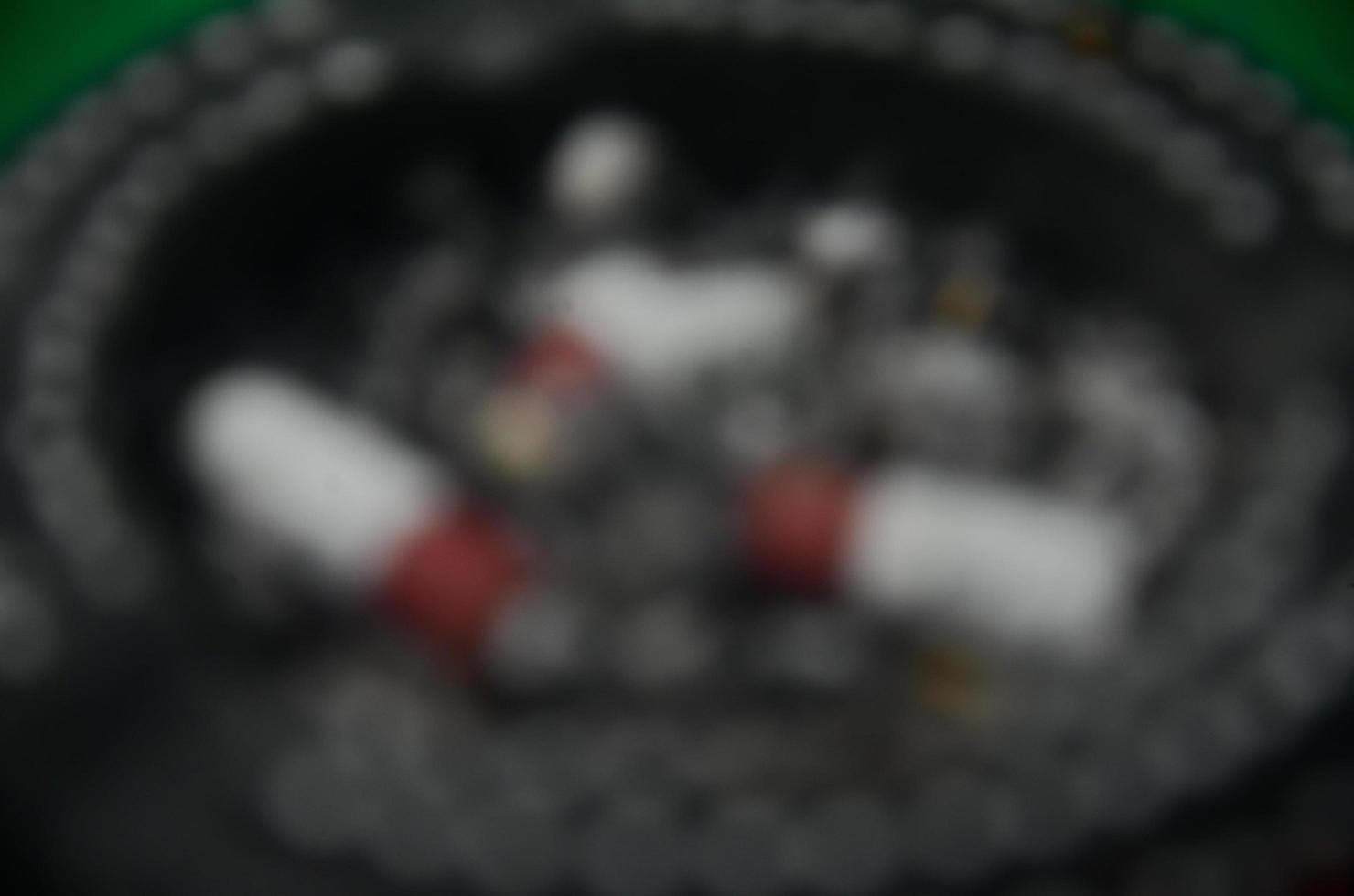 Abstract and blurry background of an ashtray and cigarettes. photo
