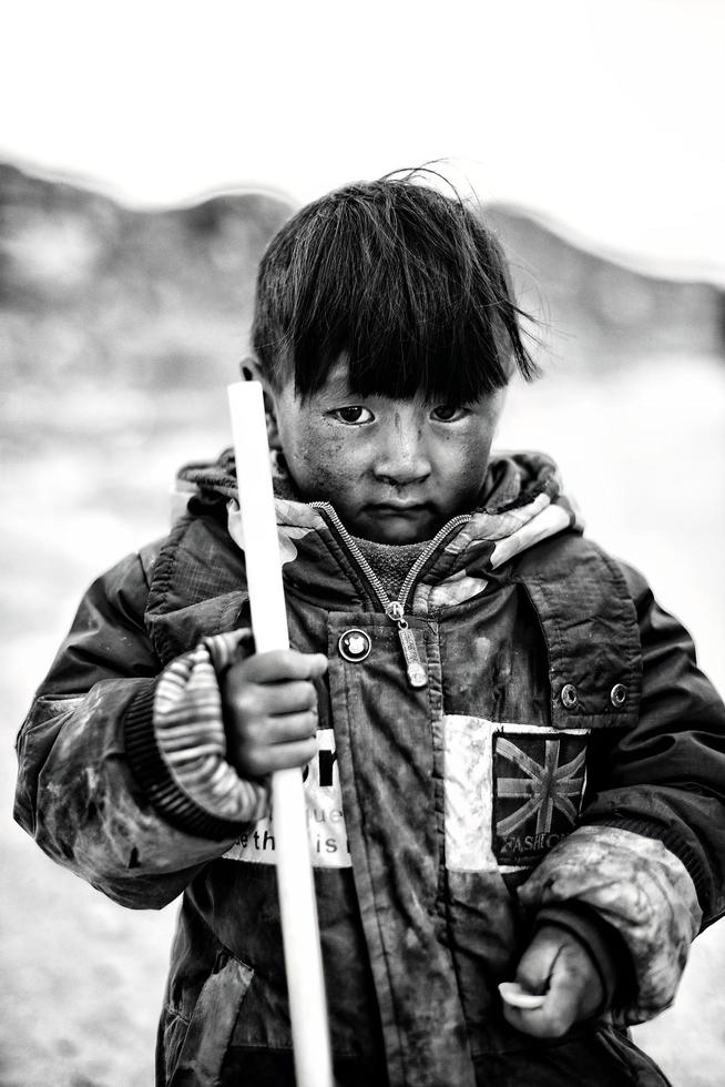 un joven pastor chico en un montaña pueblo en Tíbet foto