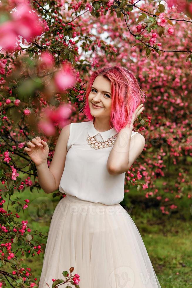 Young girl with pink hair in Apple orchard. photo
