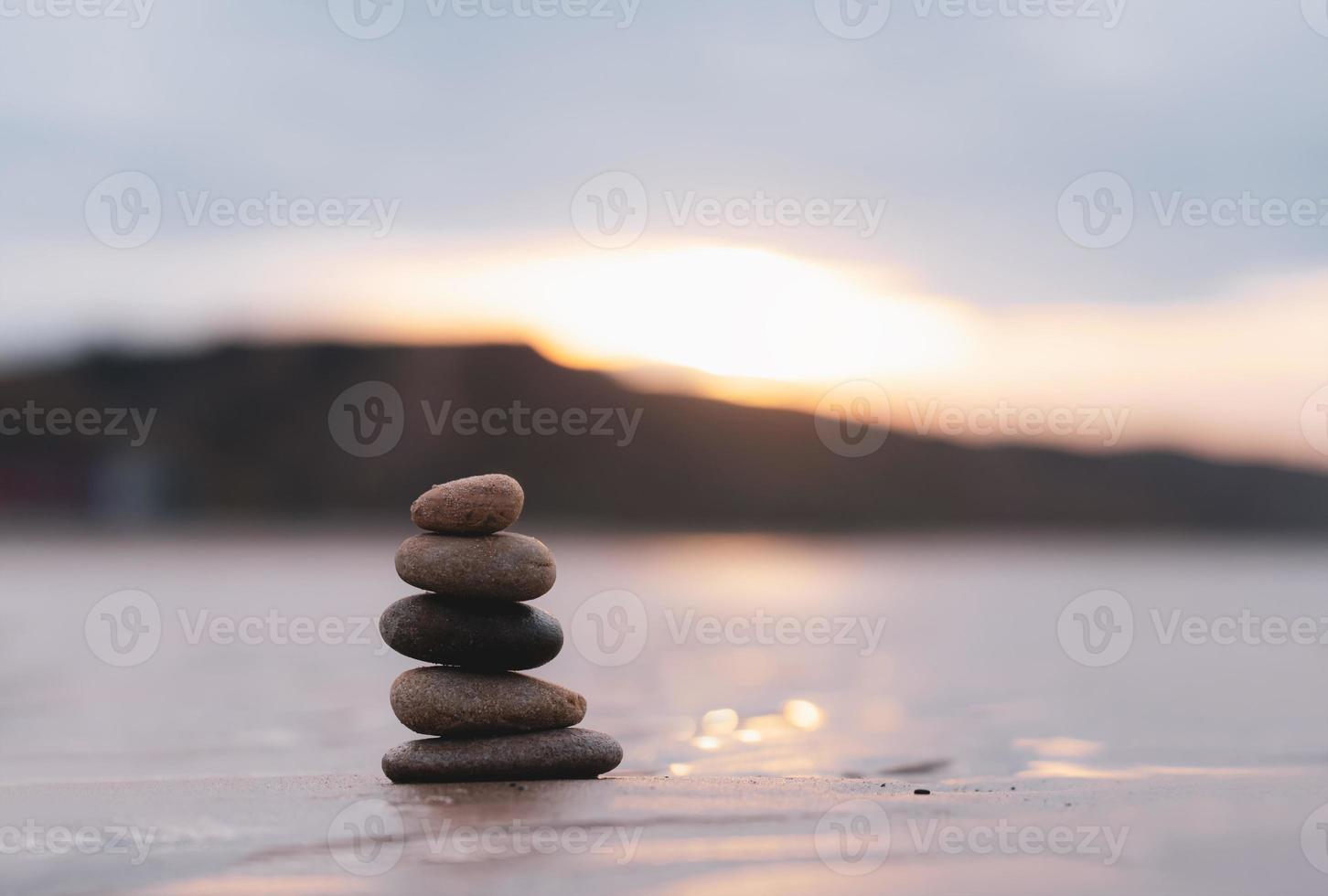 Zen stack stone on sea sand beach with blurry sunset background,Image Landscape pebble rock tower pyramid concept for stability, Harmony, Life balance,Meditation, Zen like photo