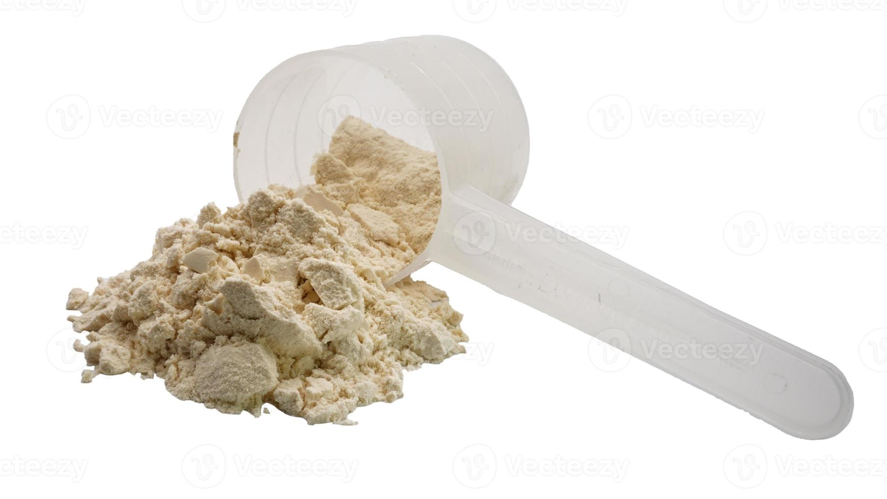 Whey protein powder in a measuring spoon isolated on white background. photo
