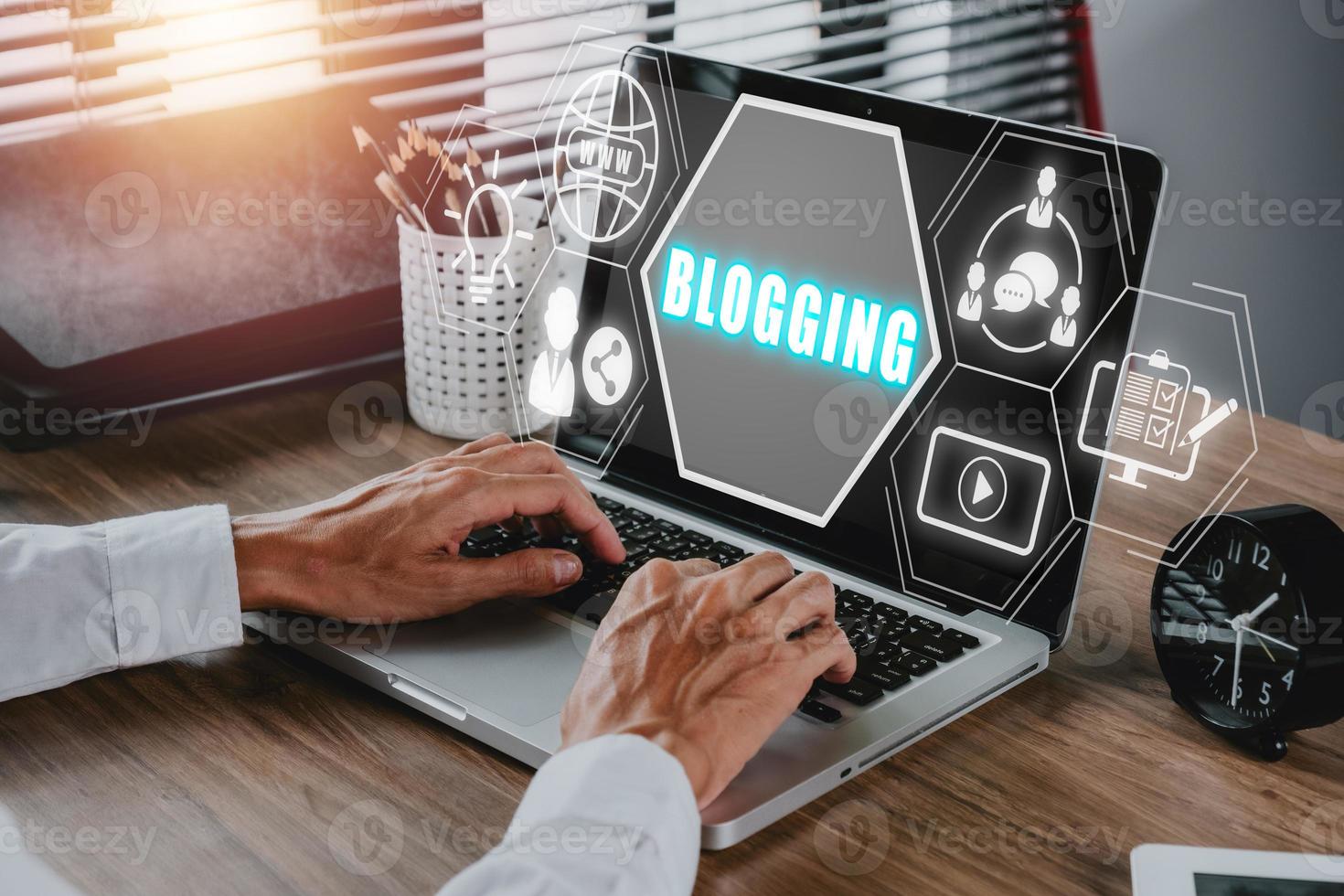 Blogging concept, Person working on laptop compuer on office desk with blogging icon on virtual screen. photo