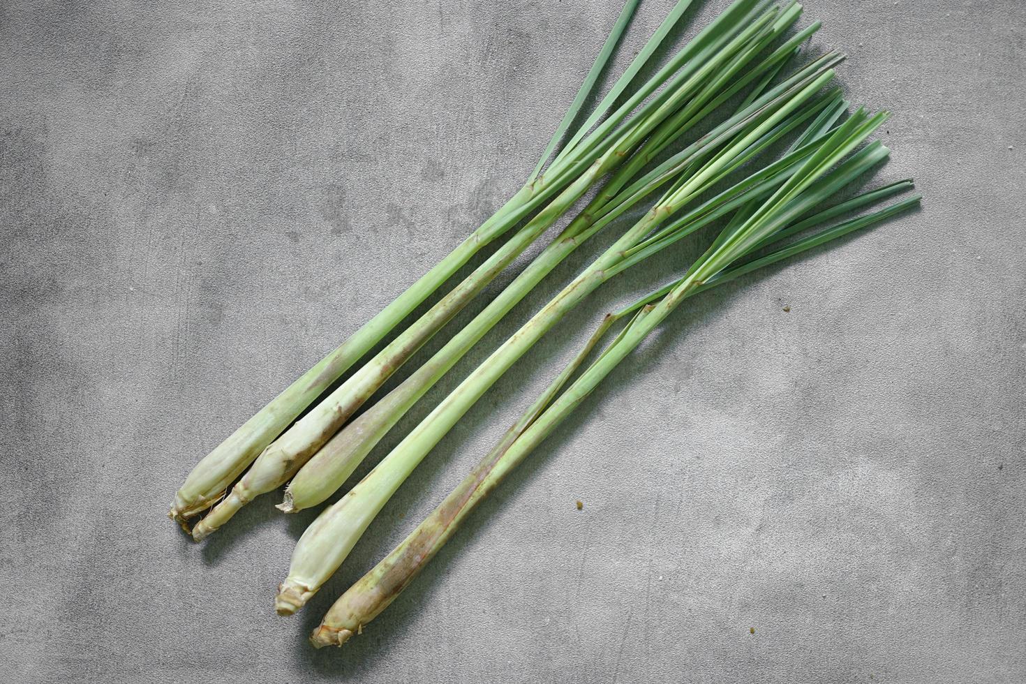 aromatic, freshly picked lemongrass leaves on concrete background photo