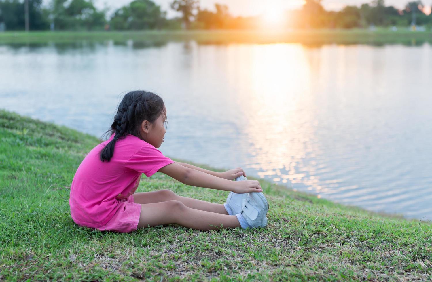 asiático pequeño niña ejercicio en parque foto