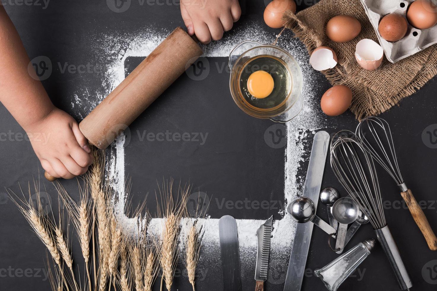 little hand with rolling pin and baking utensils photo