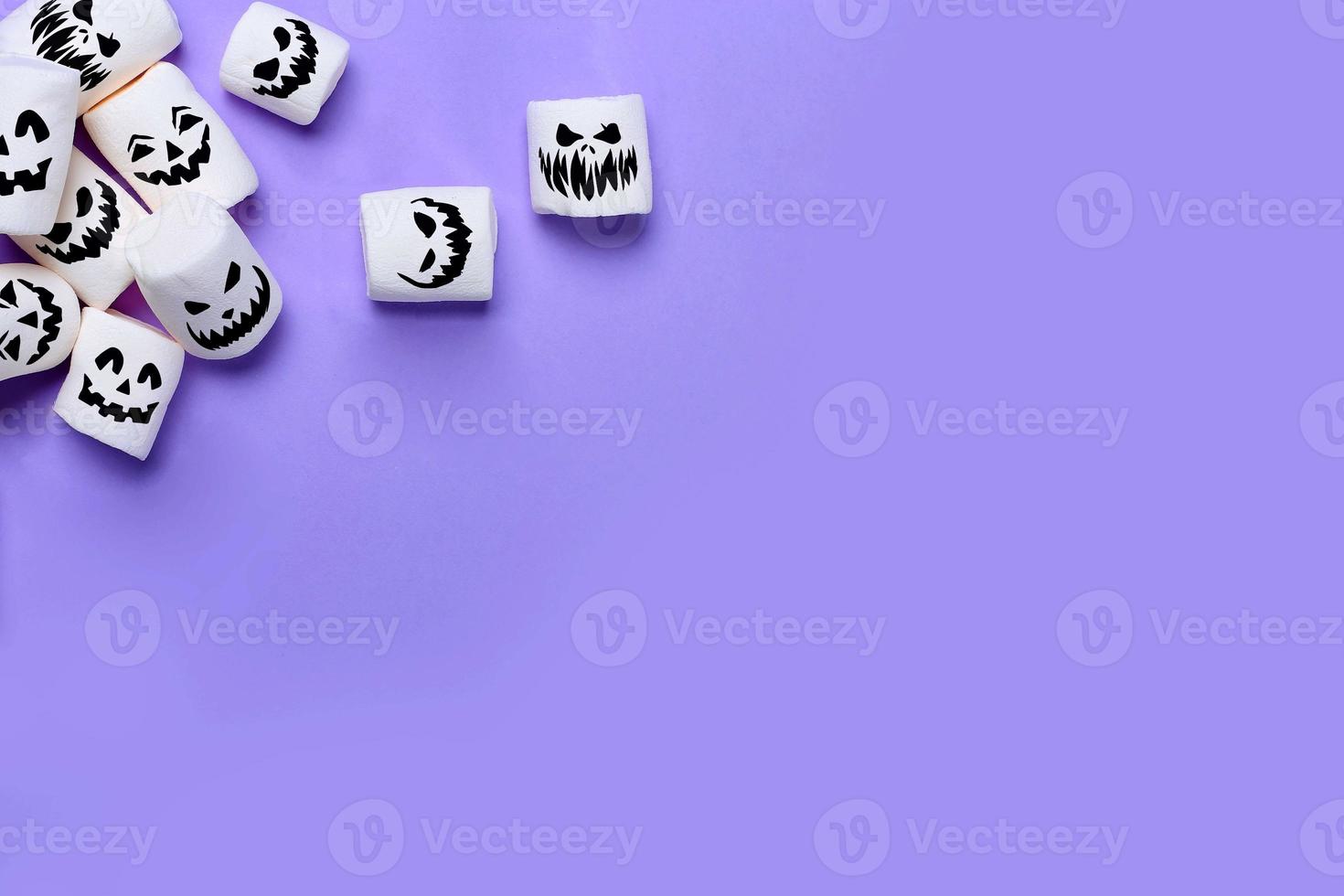 Halloween marshmallows on purple background with Copy space. Flat lay. Top view. Background or texture of white mini marshmallows. Autumn food background concept. Junk unheathy food. photo