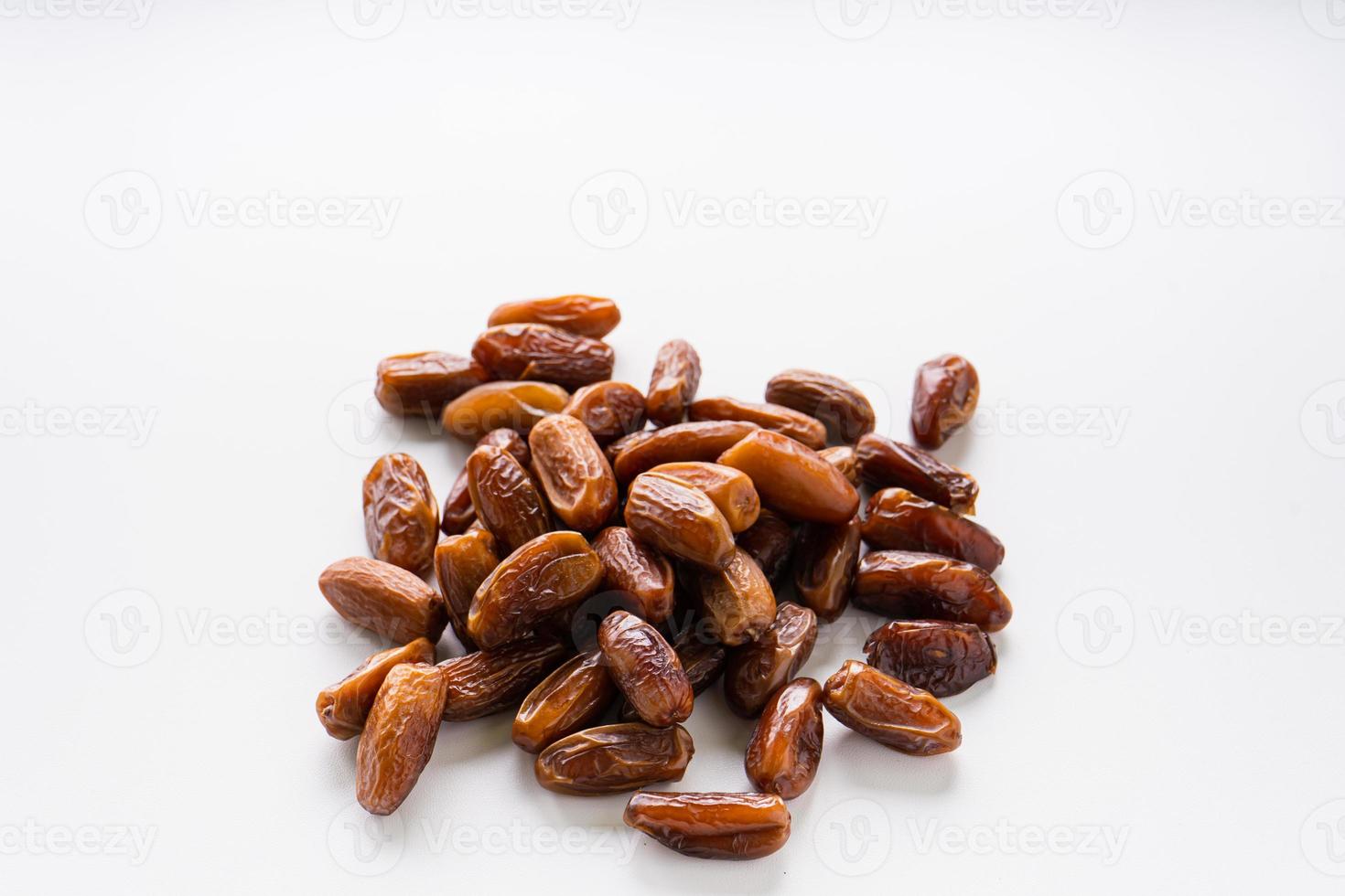 Dried dates fruit in wooden tray with soft napkin isolated on white background. photo
