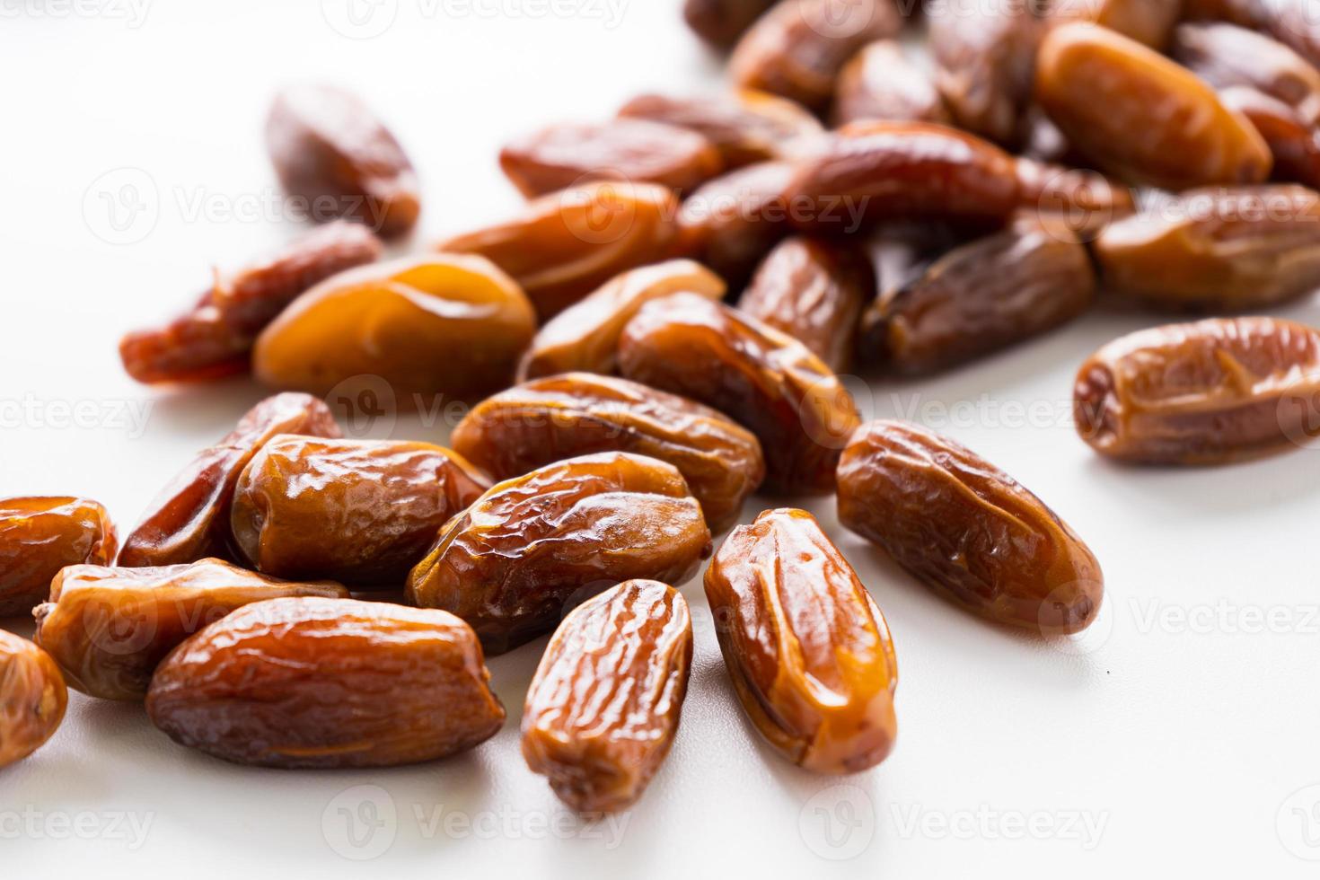 Dried dates fruit in wooden tray with soft napkin isolated on white background. photo