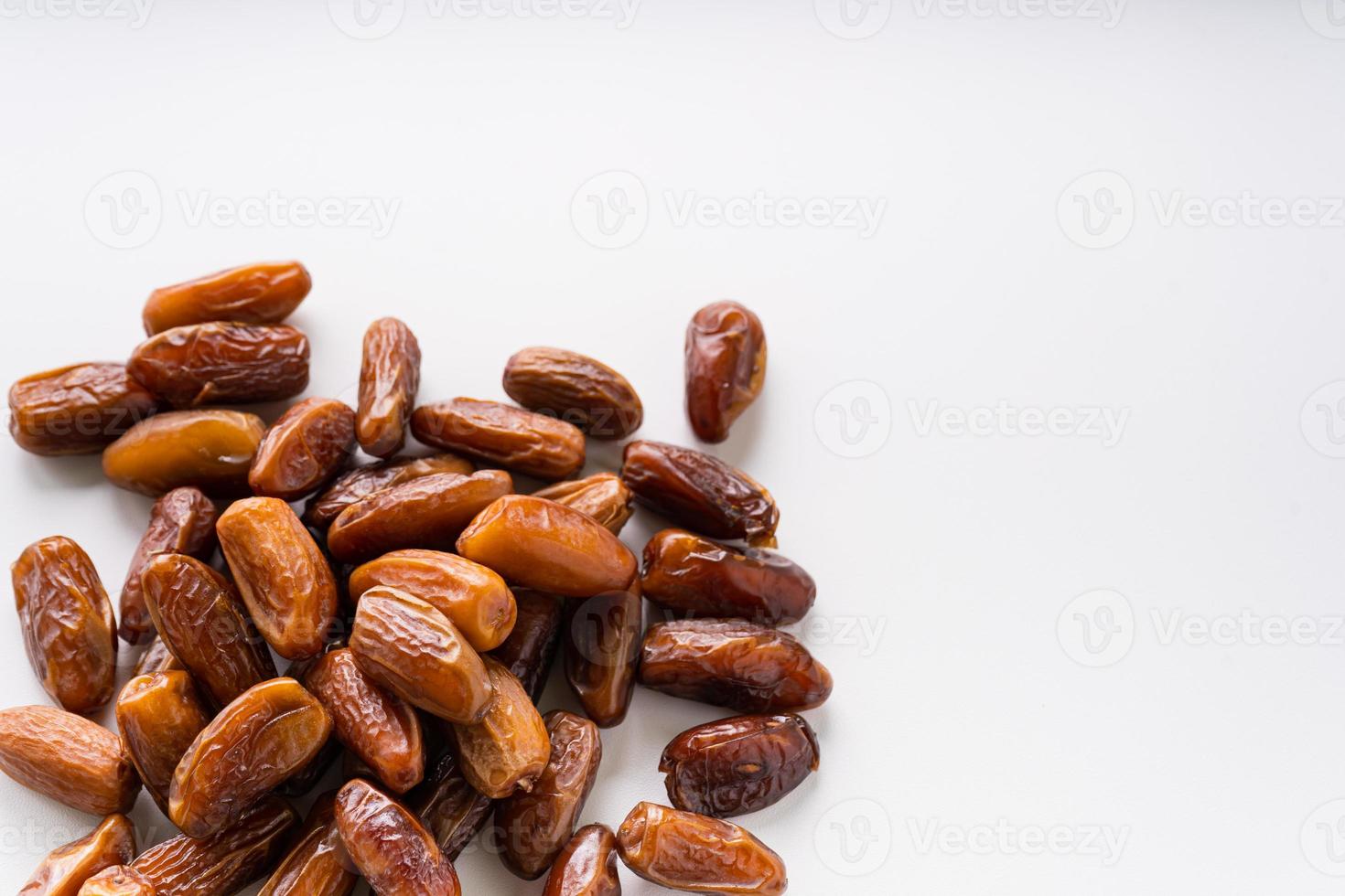 Dried dates fruit in wooden tray with soft napkin isolated on white background. photo