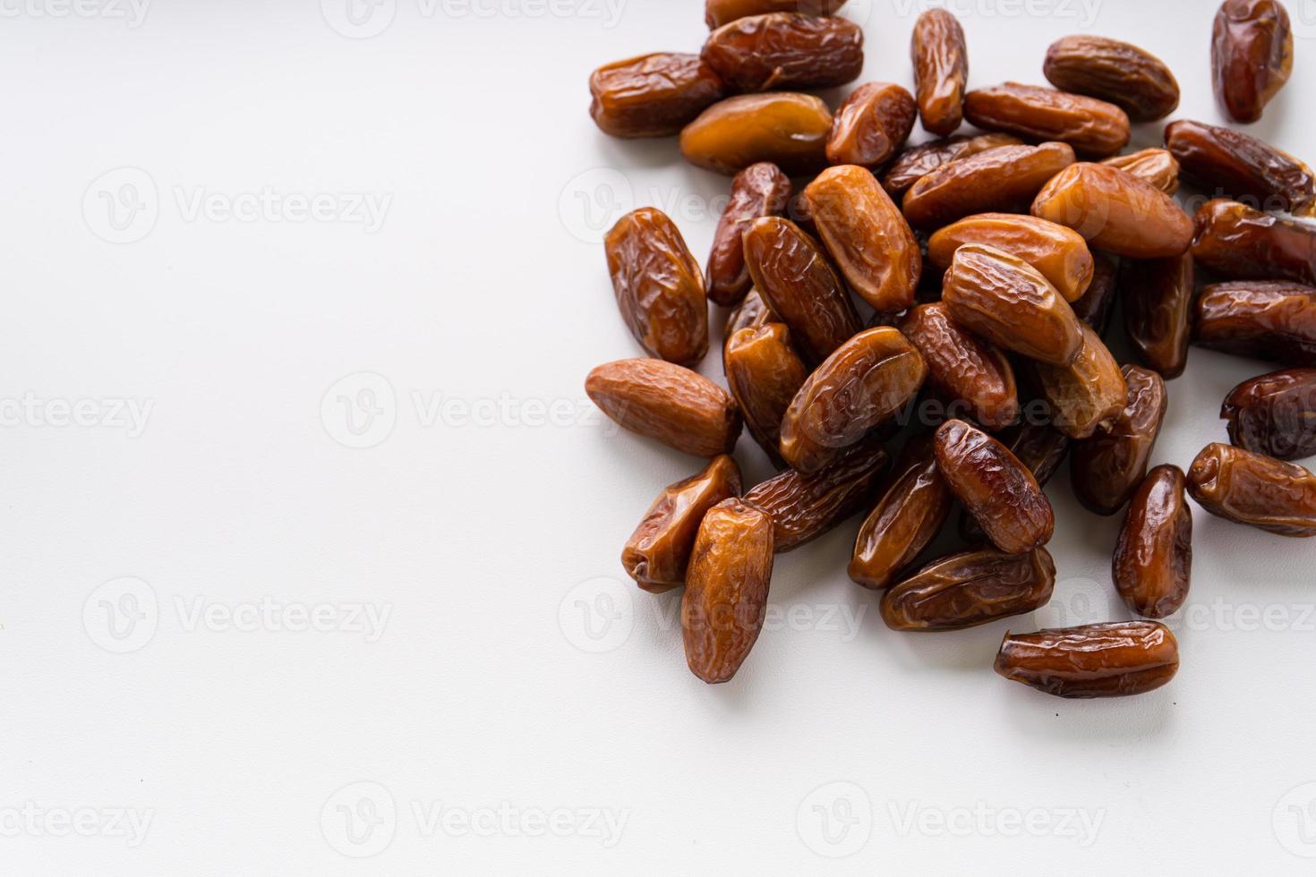 Dried dates fruit in wooden tray with soft napkin isolated on white background. photo