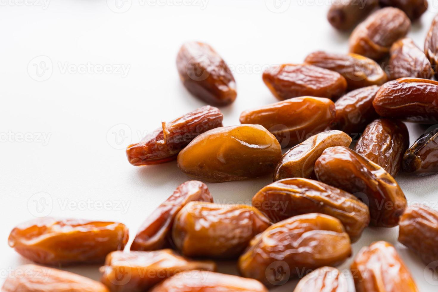 Dried dates fruit in wooden tray with soft napkin isolated on white background. photo