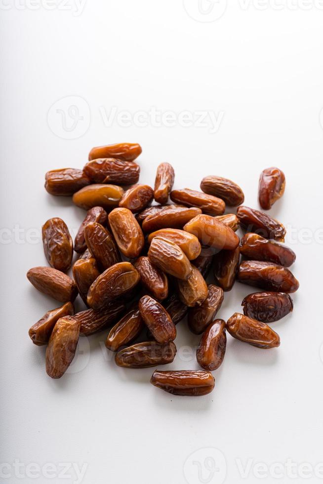 Dried dates fruit in wooden tray with soft napkin isolated on white background. photo