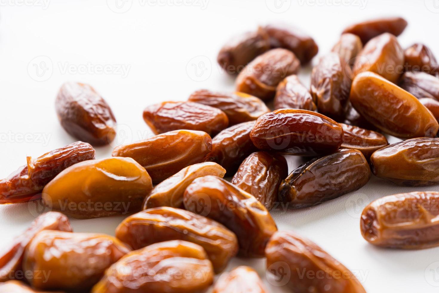 Dried dates fruit in wooden tray with soft napkin isolated on white background. photo