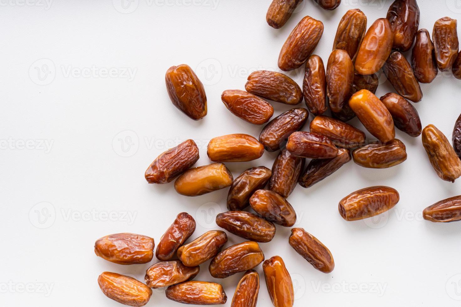 Dried dates fruit in wooden tray with soft napkin isolated on white background. photo