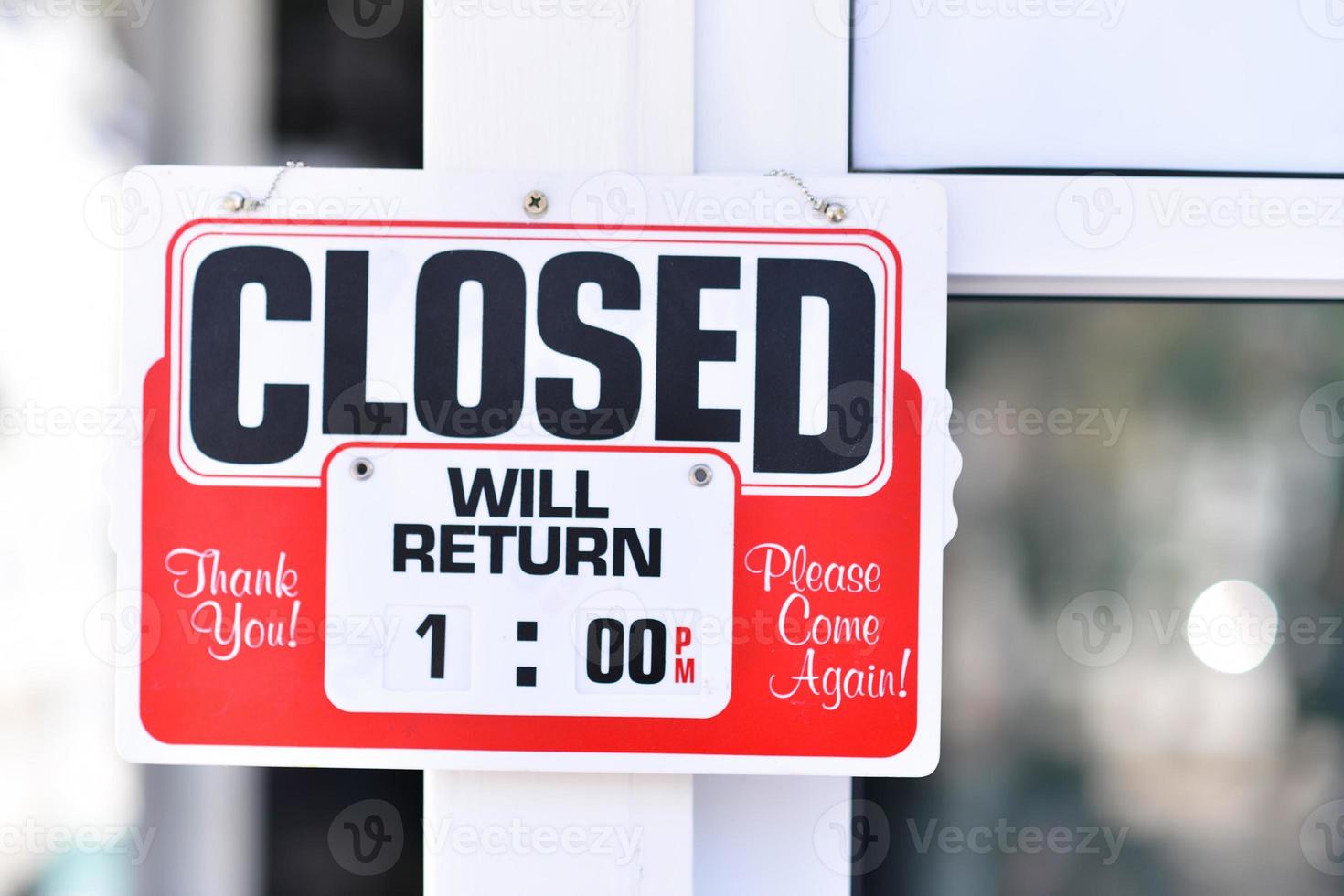 Closed sign and retuen time in a shop's window photo