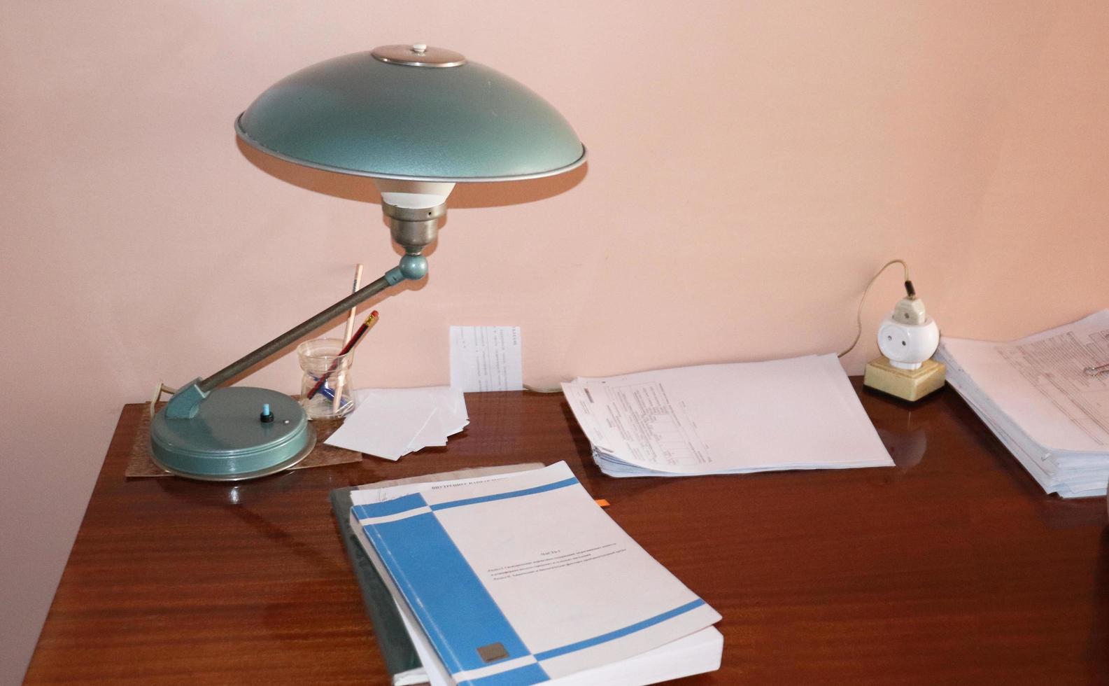 photo retro work desk with documents and table  lamp