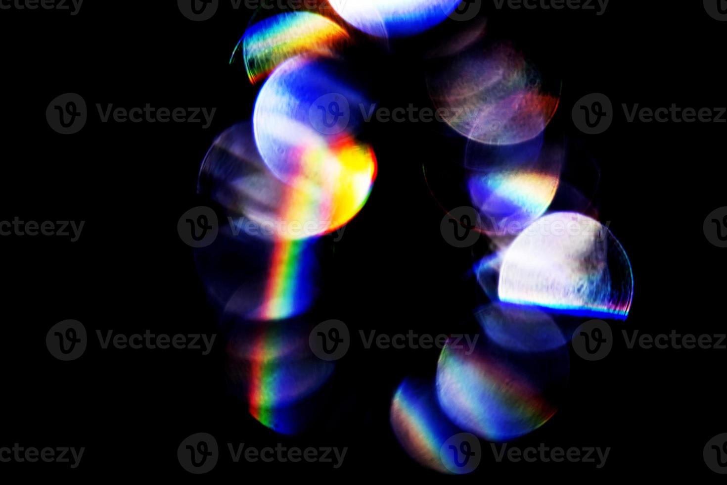 Lens flare, Bokeh lights. Reflections from glass, diamond, crystal. Defocused shining colorful rainbow light leaks, rays on black background photo