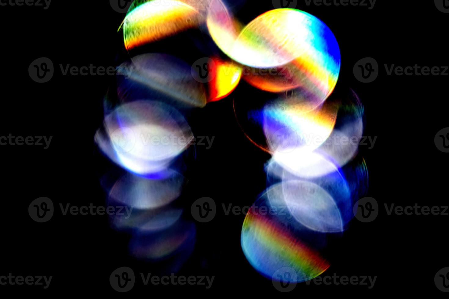 Lens flare, Bokeh lights. Reflections from glass, diamond, crystal. Defocused shining colorful rainbow light leaks, rays on black background photo