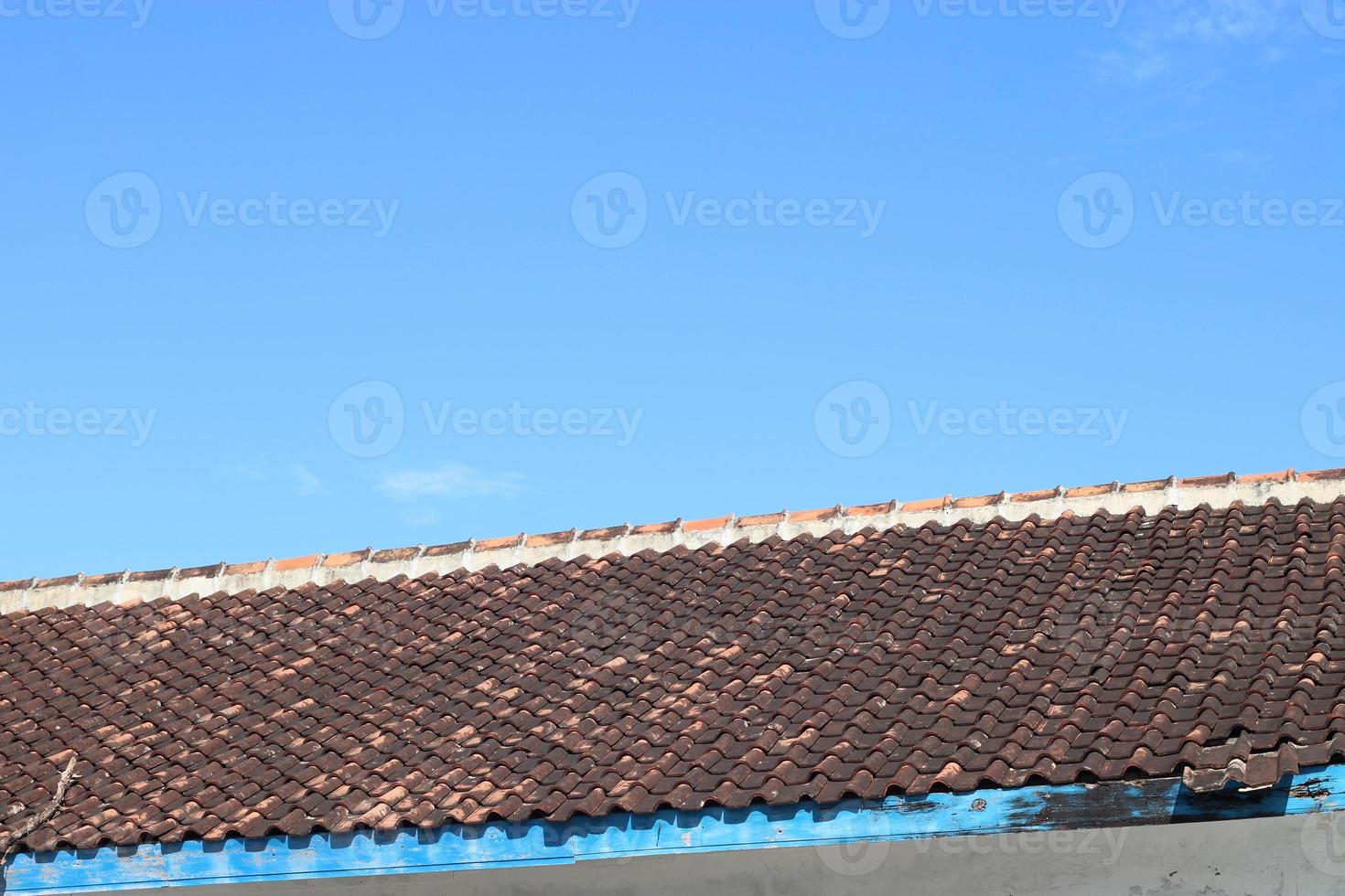 photo of the blue sky above the roof tiles of the house