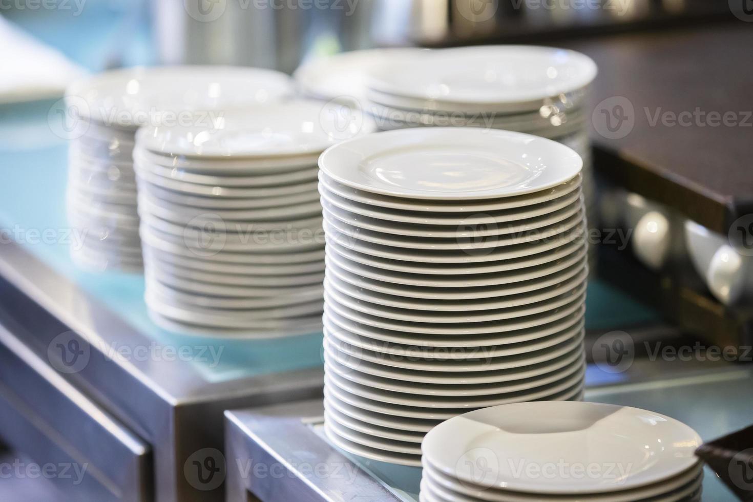 Stacks of empty white plates on a restaurant table. photo