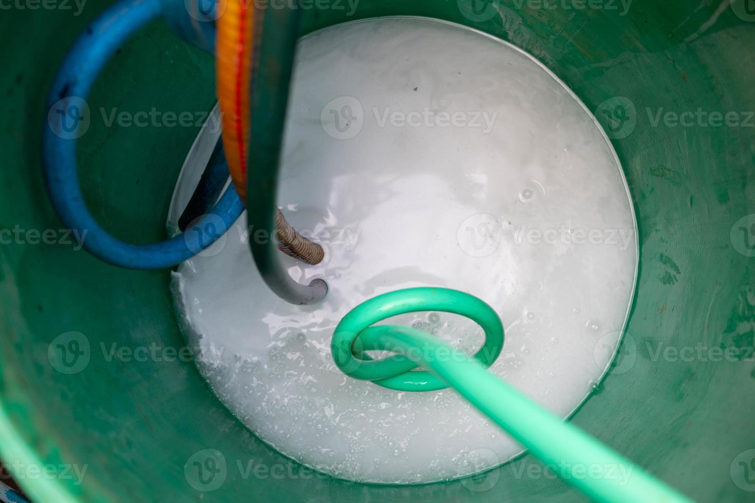 exterminate termite control company employee is using a termite sprayer at customer's house and searching for termite nests to eliminate. exterminate control worker spraying chemical insect repellant photo