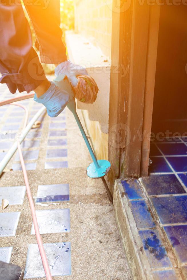 exterminate termite control company employee is using a termite sprayer at customer's house and searching for termite nests to eliminate. exterminate control worker spraying chemical insect repellant photo