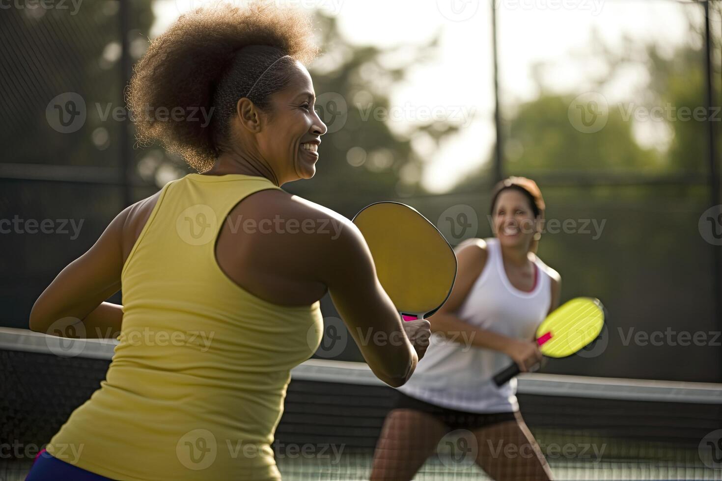 Photo of an afro girl holding a pickleball racquet on a pickleball court.