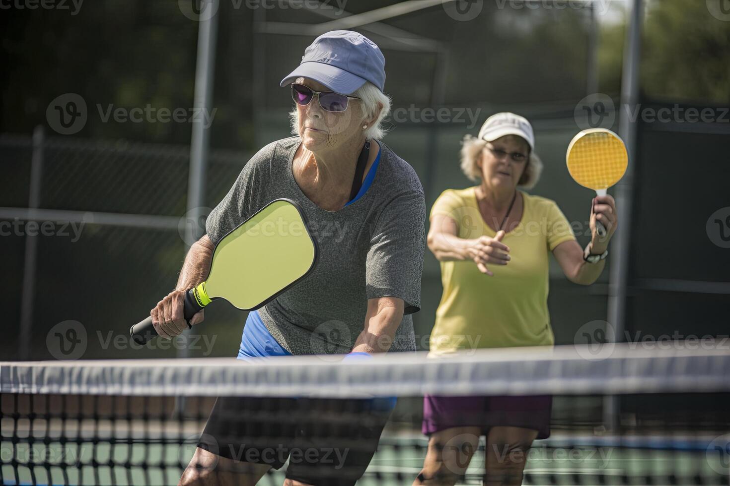Photo of an old lady holding a pickleball racquet on a pickleball court.