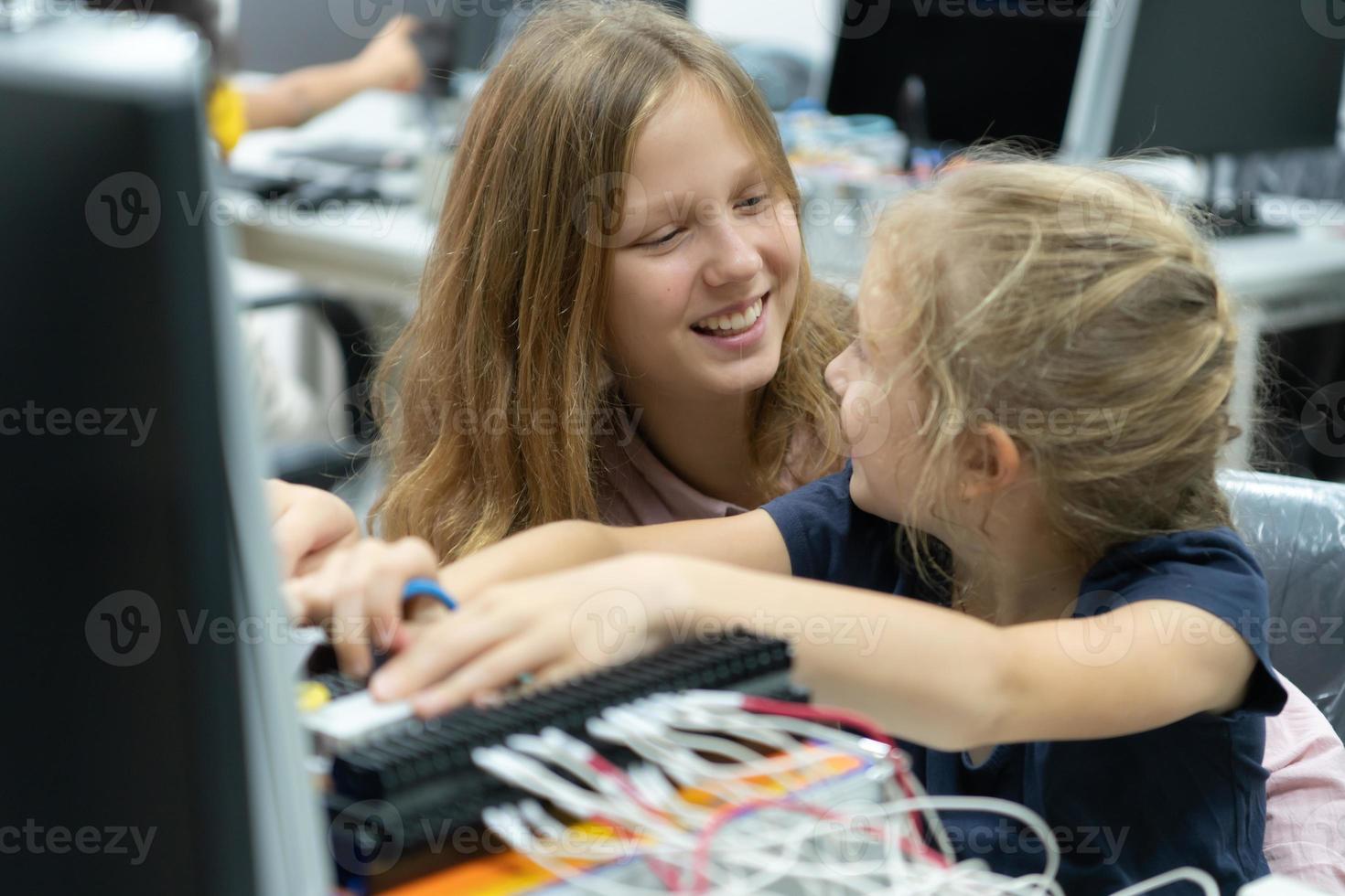 Children using the hand robot technology and having fun Learning the electronic circuit board of hand robot technology, which is one of the STEM courses. photo