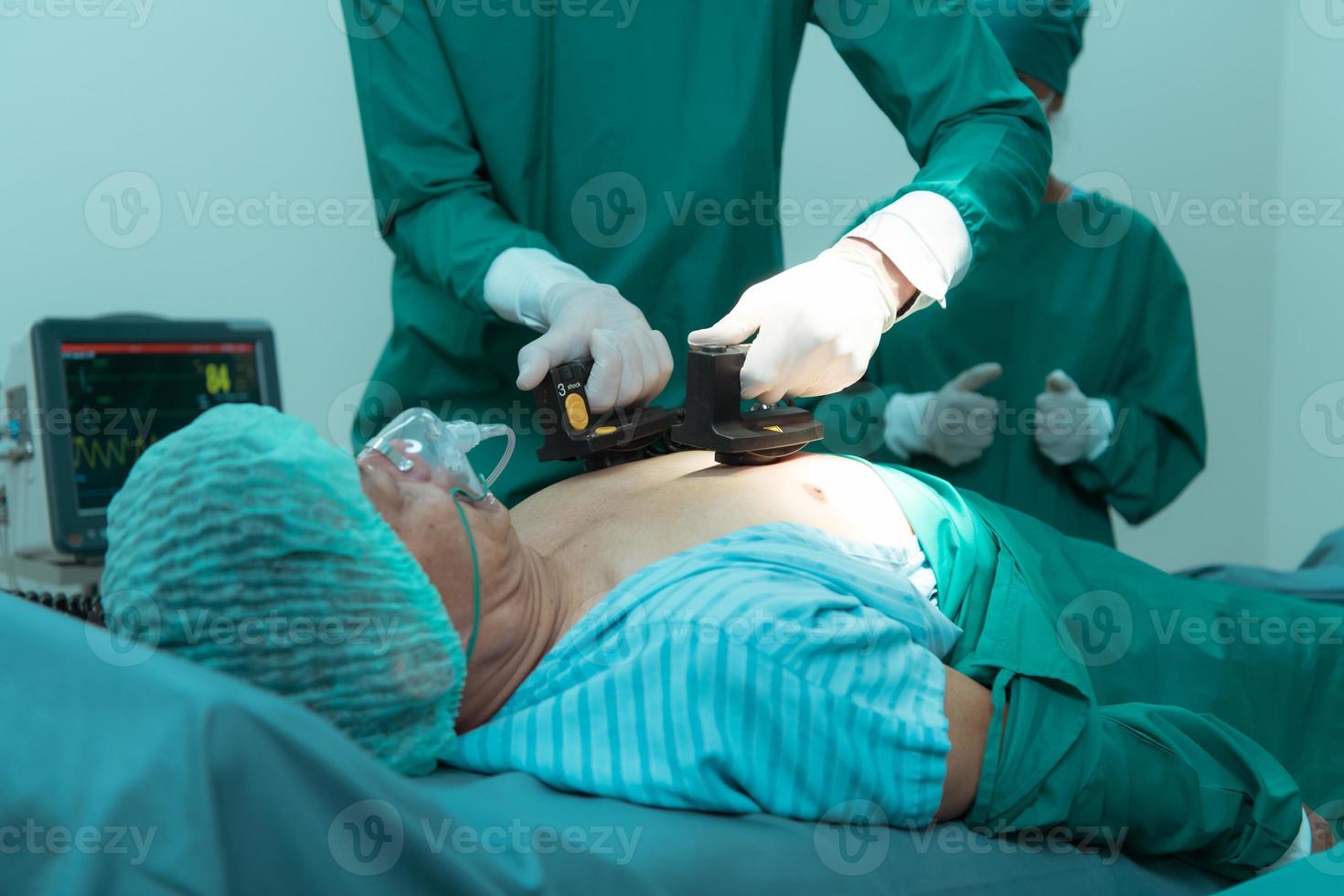 un equipo de doctores en el operando habitación realiza cpr en un paciente quien es sufrimiento desde conmoción desde corazón fracaso. foto