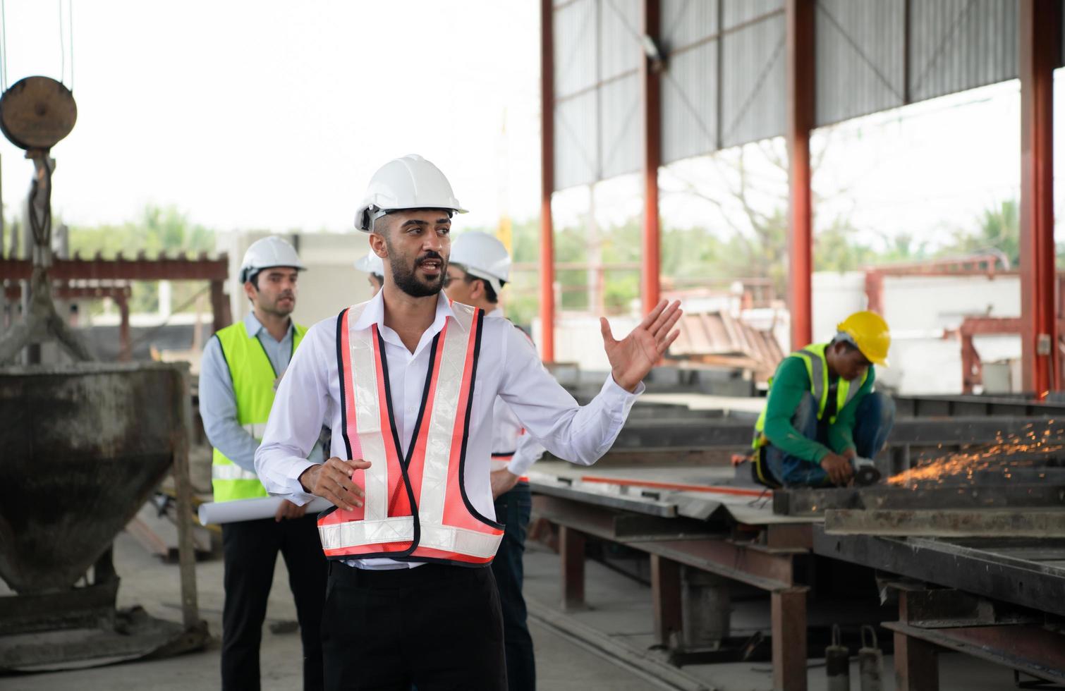 grupo de arquitectos, construcción capataces, y construcción ingenieros revisión el trabajo y hablar acerca de cómo el proyecto, en el construcción sitio. foto