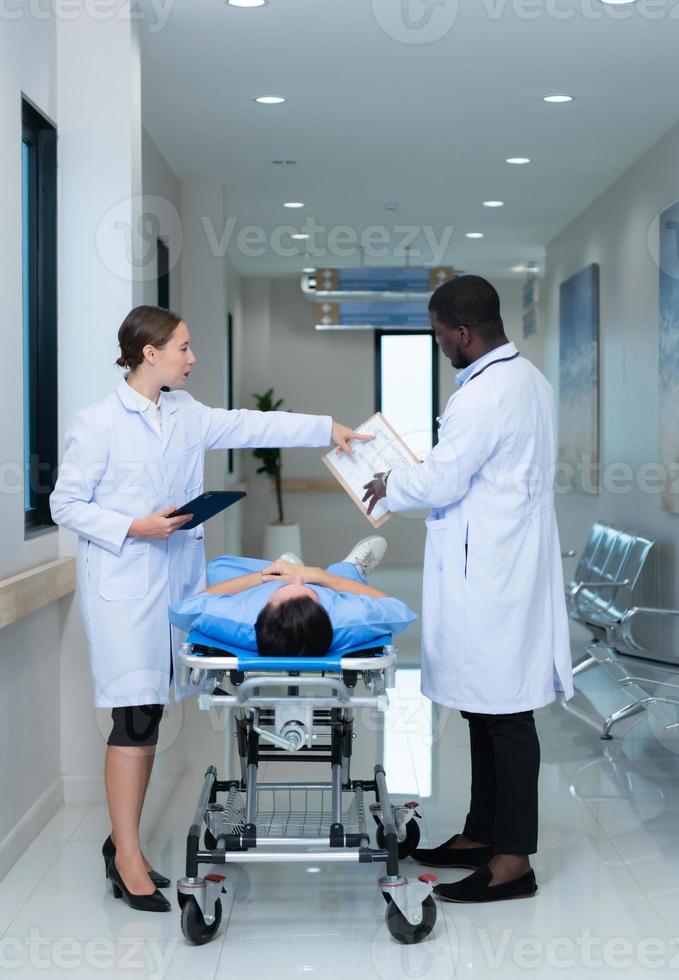 médico profesor y interno mirando a un mri de un paciente quien recibido un concusión a el cabeza después un accidente. y informar el paciente ese el cerebro es normal foto