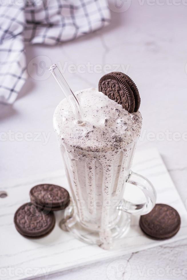 Homemade smoothie with cream and whipped chocolate chip cookies in a glass  vertical view photo