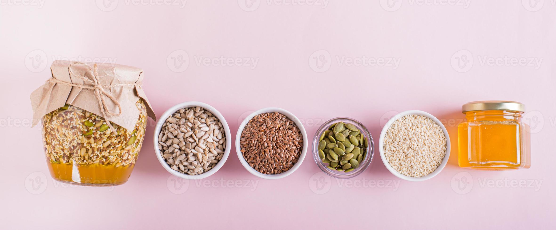 Healthy mixture of honey and various seeds in a jar and ingredients for cooking top view web banner photo