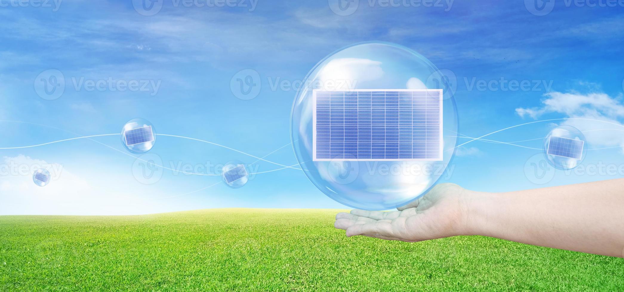 Solar panel in a bubble floating on hand Floating in the air, with grass and sky in the background. Solar energy concept. Clean energy. photo