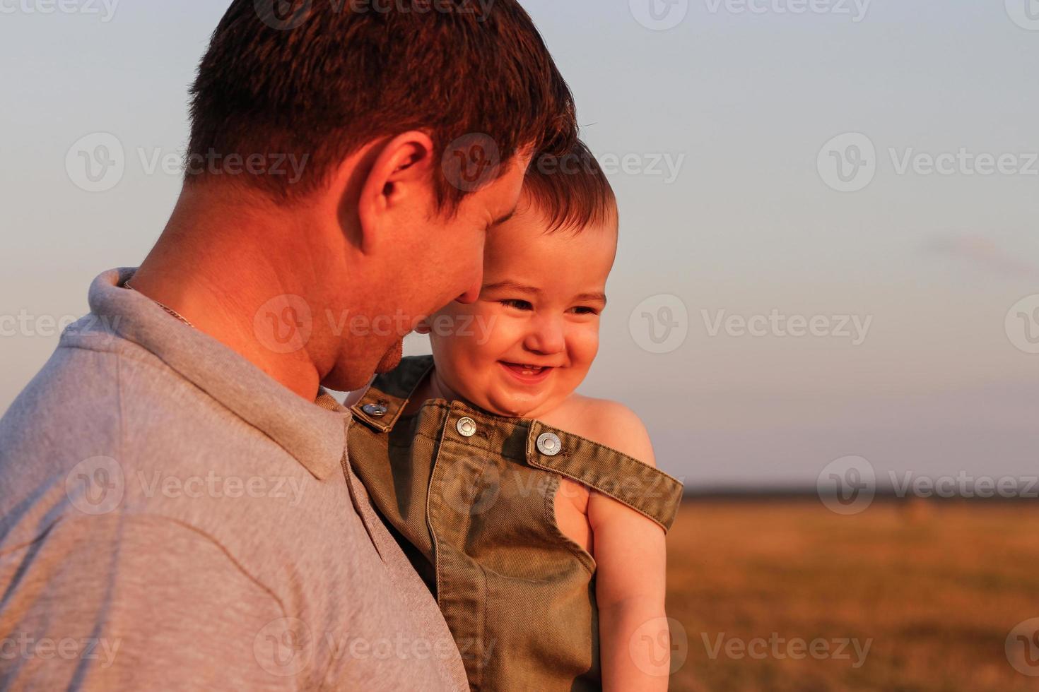 Happy dad and son on the field on a hot summer day. Concept of friendly family and of summer vacation photo