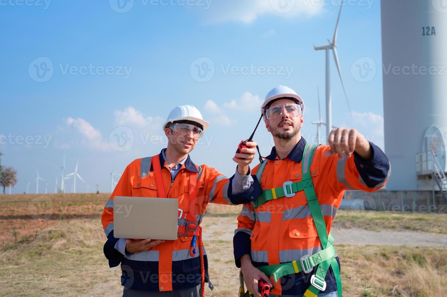 topógrafo y ingeniero examinar el eficiencia de gigantesco viento turbinas ese transformar viento energía dentro eléctrico energía ese es luego usado en diario vida. foto