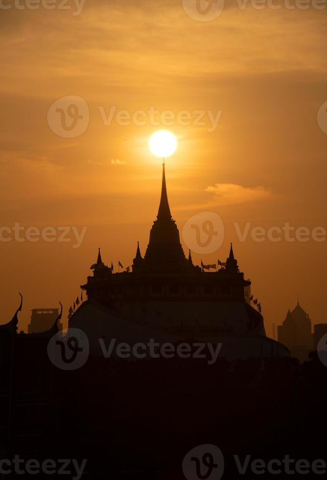 At a temple in the central of Bangkok Thailand, The morning sun will gradually move up to stand out at the end of this temple pagoda. This miracle happens only twice a year. photo