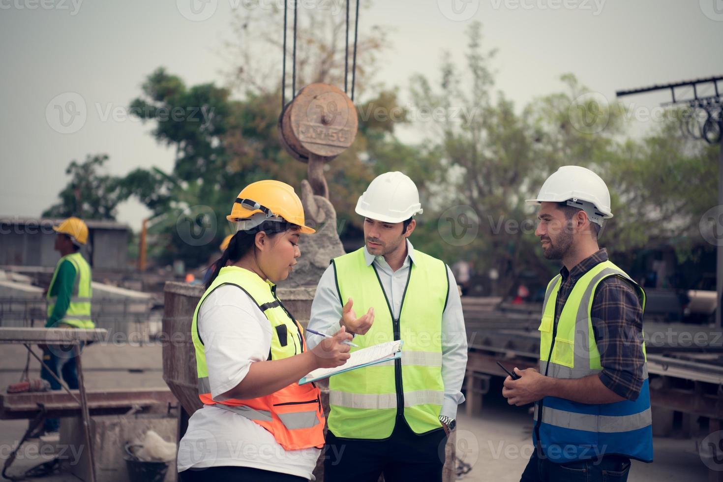 grupo de arquitectos, construcción capataces, y construcción ingenieros revisión el trabajo y hablar acerca de cómo el proyecto, en el construcción sitio. foto