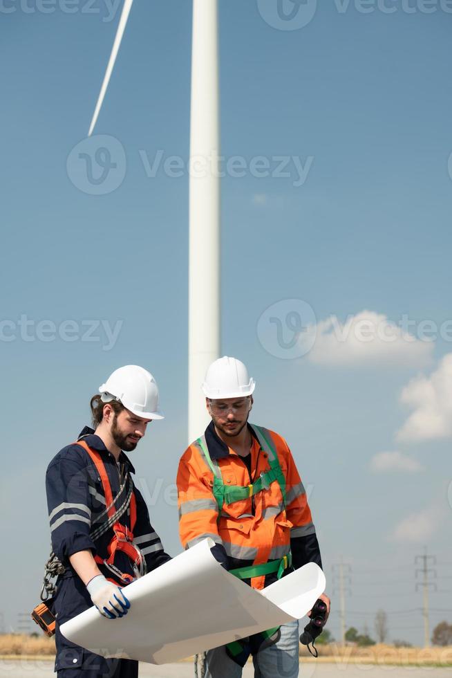 Surveyor and engineer Examine the efficiency of gigantic wind turbines that transform wind energy into electrical energy that is then used in daily life. photo